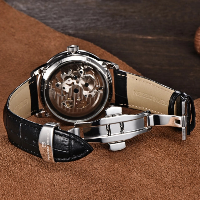 Watch with black leather strap and visible mechanical components on a brown surface